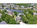The aerial view showcases the home's serene setting with a lake and the surrounding neighborhood at 709 Triple Oak Ln., Garden City Beach, SC 29576