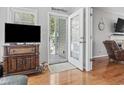 Inviting view of the living room with hardwood floors, a TV, and an open door to the deck at 709 Triple Oak Ln., Garden City Beach, SC 29576