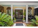Charming front entrance featuring double doors, brick patio, and decorative columns with flourishing plants at 81 Prestwick Dr., Pawleys Island, SC 29585