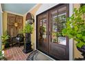 Inviting front porch boasts brick flooring, double doors, and a stylish decor with potted plants and furniture at 81 Prestwick Dr., Pawleys Island, SC 29585