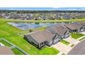 Beautiful aerial view of home with pond, landscaped lawn, white fence, and neighborhood at 892 Harrison St., Myrtle Beach, SC 29579