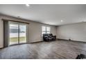 Bright living room with sliding glass doors, neutral walls, and wood-look flooring at 960 Corn Husk Loop, Conway, SC 29527