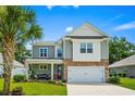 Inviting two-story home with a red front door, a cozy porch, and a two-car garage at 1007 Oak Marsh Ln., North Myrtle Beach, SC 29582
