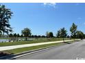 Inviting community street view featuring a tranquil lake, walking path, and landscaped green spaces enhancing neighborhood appeal at 1083 Milford Way, Myrtle Beach, SC 29588