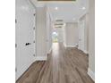 Bright hallway with wood-look tile flooring, white trim, and natural light streaming through the outdoor deck at 1112 Whispering Winds Dr., Myrtle Beach, SC 29579