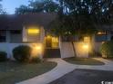 Exterior view of townhome at dusk showcasing illuminated walkway and mature trees at 18 Canvas Back Cove # 122, Georgetown, SC 29440