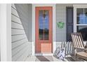 Charming front door adorned with seasonal decor, complemented by a rocking chair on a welcoming porch at 1838 Zodiac Court, Myrtle Beach, SC 29577
