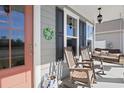 Inviting front porch with rocking chairs, a swing, and cheerful decorations creating a cozy outdoor space at 1838 Zodiac Court, Myrtle Beach, SC 29577