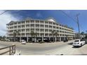 Multi-story condo building featuring numerous balconies, ground level parking, and palm trees on street front at 200 53Rd Ave. N # 205, North Myrtle Beach, SC 29582