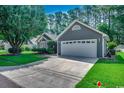 Well-maintained single-story home with an attached garage and green lawn at 220 Gateway Dr., Little River, SC 29566