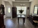 Elegant dining room featuring hardwood floors, a modern chandelier, and a glass-top table at 2594 W Shore Dr., Longs, SC 29568