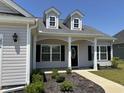 Inviting front entrance featuring a stylish front door, dormer windows, and manicured landscaping at 2594 W Shore Dr., Longs, SC 29568