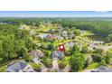 Beautiful aerial view of the neighborhood, showcasing lush greenery, community pool, and pond at 312 Caldera Ct., Murrells Inlet, SC 29576