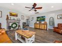 Cozy living room with hardwood floors, fireplace, ceiling fan, and comfortable seating at 318 Board Landing Circle, Conway, SC 29526