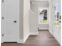 Bright foyer with wood floors, a staircase, a large window, and a classic white door at 4329 Landing Rd., Little River, SC 29566
