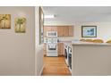Bright kitchen featuring white appliances, wood floors and cabinets, and a laundry area at 4719 S Ocean Blvd. # 108, North Myrtle Beach, SC 29582