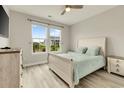 Comfortable bedroom with neutral paint, wood floors, and view of yard at 5087 Sundrop Ln., Little River, SC 29566