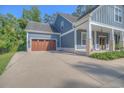 Stylish home exterior showcasing a two-car garage, a covered porch with stone accents, and manicured landscaping at 520 Oak Pond Ct., Conway, SC 29526