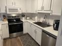 Modern kitchen with white cabinets, stainless steel appliances, and stone countertops at 812 S Ocean Blvd. # B-3, Surfside Beach, SC 29575