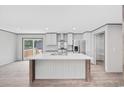 Bright kitchen features a center island, stainless steel appliances, white cabinets, and wood-look floors at 108 Forman Way, Aynor, SC 29511