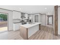 Modern kitchen features a central island, stainless steel appliances, white cabinetry and wood floors at 108 Forman Way, Aynor, SC 29511