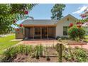 Backyard featuring a covered patio, lush garden beds, and a brick patio area at 123 Retreat Pl., Little River, SC 29566