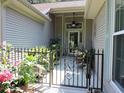 View of front entrance featuring an ornamental iron fence and gate with potted plants and a ceiling fan at 1307 Carolina Wren Ln., Murrells Inlet, SC 29576