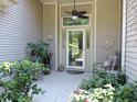 Inviting front porch with seating, ceiling fan, and decorative plants near front door at 1307 Carolina Wren Ln., Murrells Inlet, SC 29576