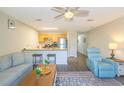 Open-concept living room featuring ceiling fan, breakfast bar, couch, and an accent chair at 1450 St. George Ln. # E, Myrtle Beach, SC 29588