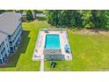 Overhead view of a fenced community pool surrounded by grass and trees next to a condo building at 1450 St. George Ln. # E, Myrtle Beach, SC 29588