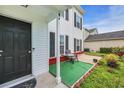Cozy front porch featuring a table, chairs, artificial turf and lush landscaping at 180 Weeping Willow Dr., Myrtle Beach, SC 29579