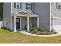Inviting front porch with a decorative wreath, lush landscaping, and a charming welcome sign at 189 Harmony Ln., Myrtle Beach, SC 29588