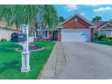 Inviting home exterior with stone walkway, palm tree, black mailbox, and vibrant flower beds adding curb appeal at 2479 Burning Tree Ln., Little River, SC 29566
