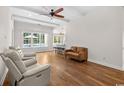 Bright living room with ceiling fan, hardwood floors, and an open layout with views of the kitchen and pool at 409 Cypress View Ave., Little River, SC 29566