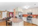 Spacious kitchen with stainless steel appliances, breakfast bar, and open view to the living room at 943 Oak St., Aynor, SC 29511