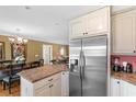 Open-concept kitchen with stainless steel refrigerator, breakfast bar, and view of the dining and living areas at 943 Oak St., Aynor, SC 29511