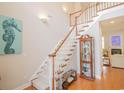 Elegant foyer boasts a staircase and display cabinet on hardwood floors with natural light at 1427 Mcmaster Dr., Myrtle Beach, SC 29575