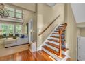 Bright foyer featuring hardwood floors, a staircase with wood and iron railings, and a glimpse into the living room at 154 Harbor Oaks Dr., Myrtle Beach, SC 29588