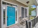 Inviting front porch with a vibrant blue door, quaint seating, and stylish black shutters and railing at 154 Harbor Oaks Dr., Myrtle Beach, SC 29588