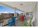 Spacious porch with colorful rocking chairs overlooking the street at 221 N Waccamaw Dr., Murrells Inlet, SC 29576
