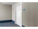 Hallway view leading to unit door, with neutral paint, blue accents, and visible unit number at 300 N Ocean Blvd. # 128, North Myrtle Beach, SC 29582