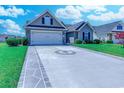 Well-maintained home featuring a two-car garage, a decorative driveway, and manicured landscaping at 35 Palmetto Green Dr., Longs, SC 29568