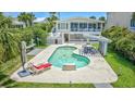 Backyard pool area featuring a unique shape, lounge chairs, covered patio, and manicured lawn at 624 Dogwood Dr. S, Garden City Beach, SC 29576