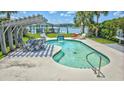 Inviting pool with chairs, a small waterfall, and a nearby pergola overlooking the water at 624 Dogwood Dr. S, Garden City Beach, SC 29576