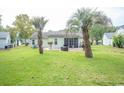 Expansive backyard with palm trees and a patio, perfect for outdoor entertaining at 654 Blue Bird Ln., Murrells Inlet, SC 29576
