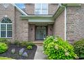 Inviting home entryway featuring a decorative glass door, brick facade, and mature shrubbery at 8013 Wacobee Dr., Myrtle Beach, SC 29579