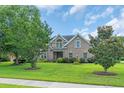 Beautiful home with lush front lawn and mature trees, offering serene suburban living at 8013 Wacobee Dr., Myrtle Beach, SC 29579