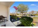 Inviting front porch with a wicker chair, view of the landscaped front yard and street at 864 Barn Owl Ct. # 864, Myrtle Beach, SC 29579