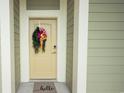 Charming front door with a 'hello' door mat and a decorative wreath, with neutral paint at 130 Puffin Dr. # 2B, Pawleys Island, SC 29585