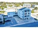 Aerial view of the teal three-story building with balconies and parking lot, surrounded by trees and other buildings at 200 S Ocean Blvd. # 3-B, North Myrtle Beach, SC 29582